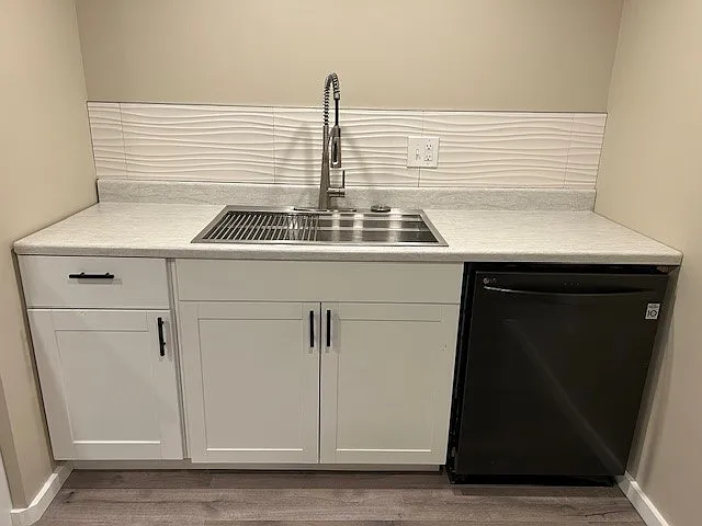 Over-size stainless steel sink, tile backsplash.