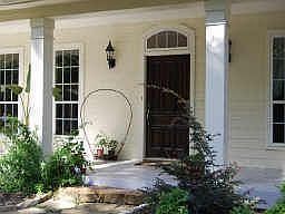 An oversized front door, a huge stone step, and a wide front porch welcome friends and neighbors.