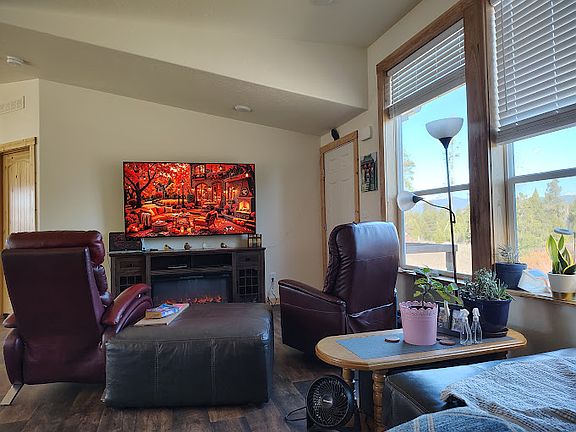 Large smart TV in spacious living room with mountain views.