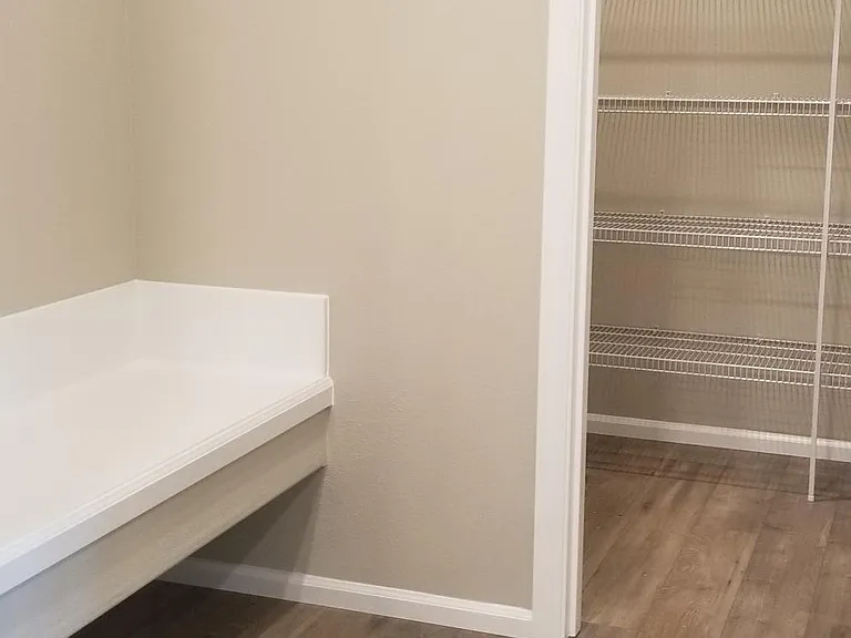 What a convenience to be able to sit in the mudroom, remove footwear and stash groceries in the pantry!