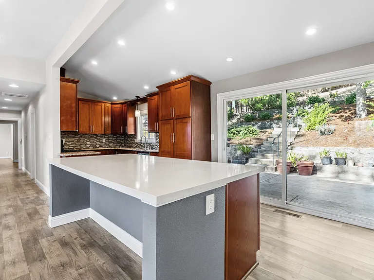 Open kitchen overlooking back patio and landscaping
