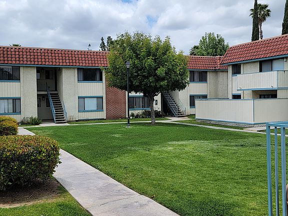 Private patios and balconies around grassy courtyard and pool at Magnolia Apartments in Riverside, California.