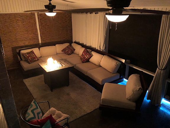 Screened in front porch with curtains and ceiling fans