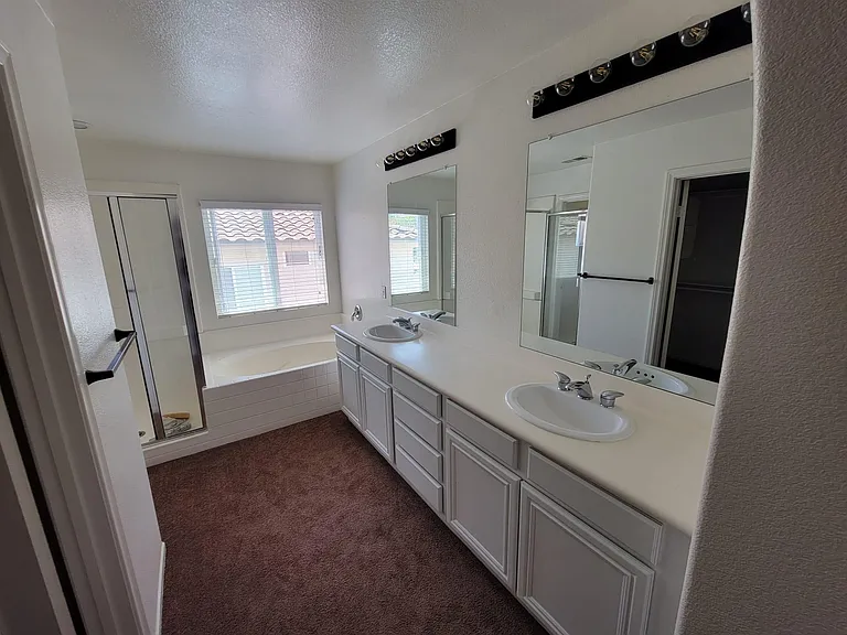Master Bathroom with two sinks, shower and a spa tub.