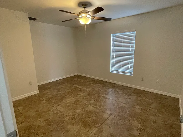 Bedroom has a new ceiling fan and freshly painted walls.