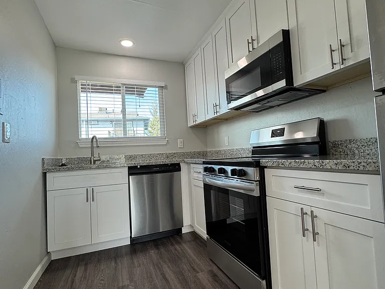 Galley style kitchen with dishwasher, garbage disposal, stove, microwave and full-size refrigerator