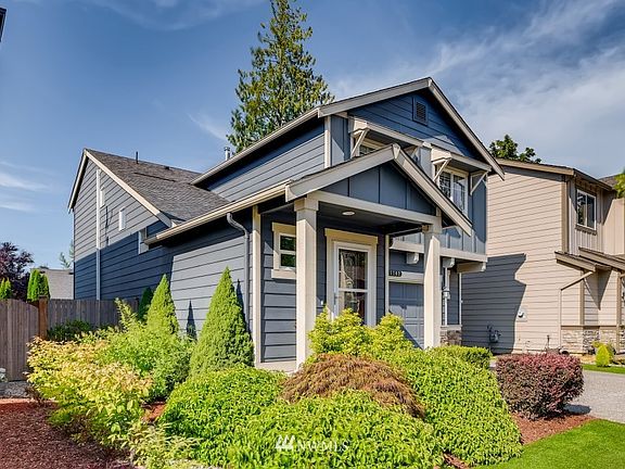 Another view of the beautiful home and landscaping. Enjoy the "easy to maintain" bushes, trees and grass year round!