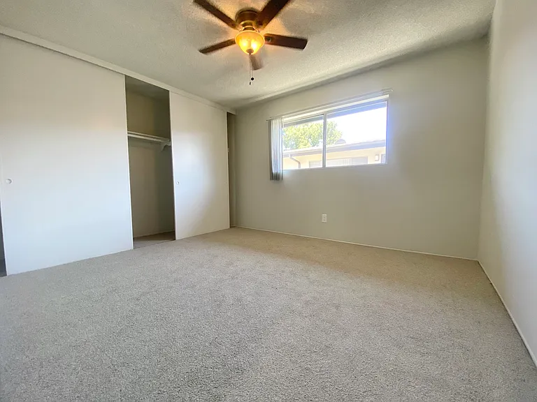 Secondary bedroom with large built-in closet, ceiling fan, and brand new, fresh plush padding and carpet