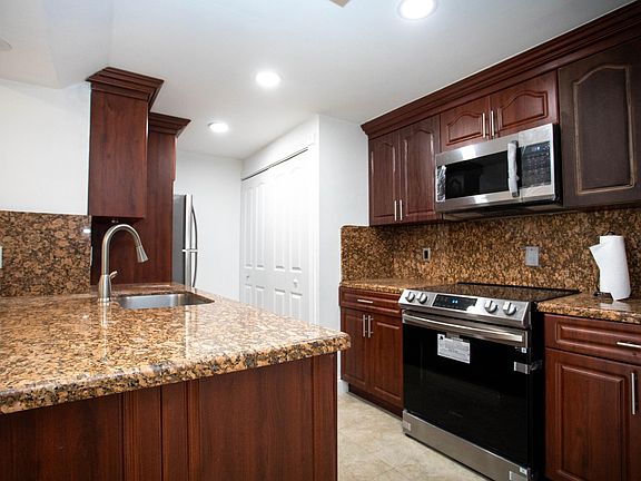 kitchen with new stove and microwave as well as washer and dryer in the closet