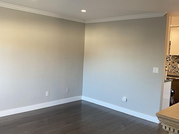 Spacious living room with recessed lighting and crown molding. Hardwood floors