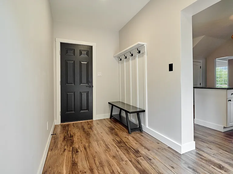 Mudroom (New Addition) showing Bench, Coat Rack, & Door to Garage.