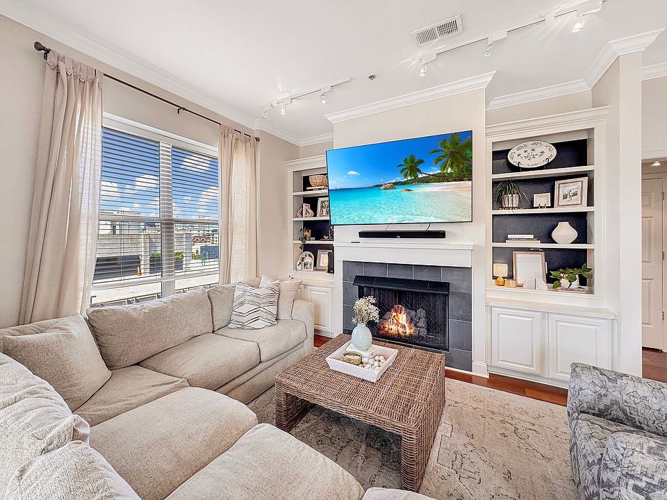 Living room with gas fireplace, bookshelfs, and beautiful view of downtown.