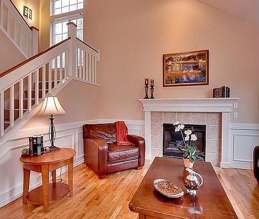 Another view of the living room with gas fireplace and stairs to 2nd floor.