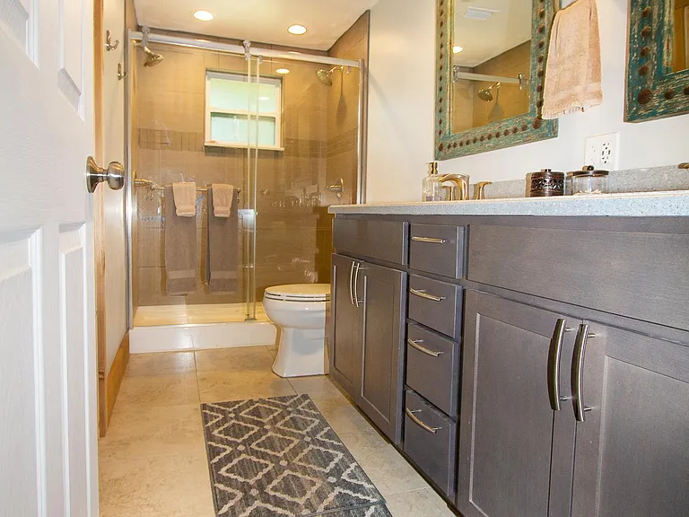 bethroom with 2 sinks and a double shower