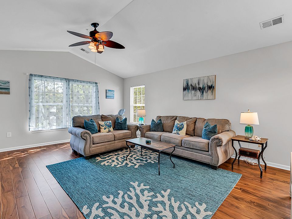 Light and area living room with vaulted ceilings and balcony access