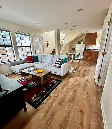 Downstairs living room and kitchen area with storage under the stairs