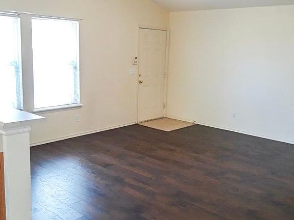 High vaulted ceiling, laminate flooring, and large living room windows for plenty of light.