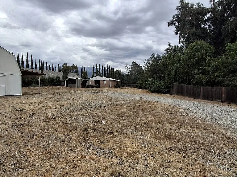 picture of portion of yard has 3 buildings besides the 3 bedroom house