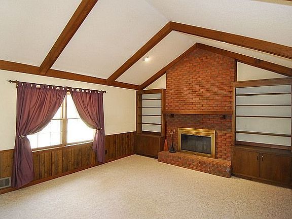 Vaulted family room with stunning brick fireplace and built in bookshelves!