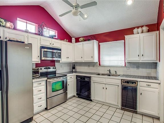 Nice sized kitchen with SS appliance and window view in front of sink.