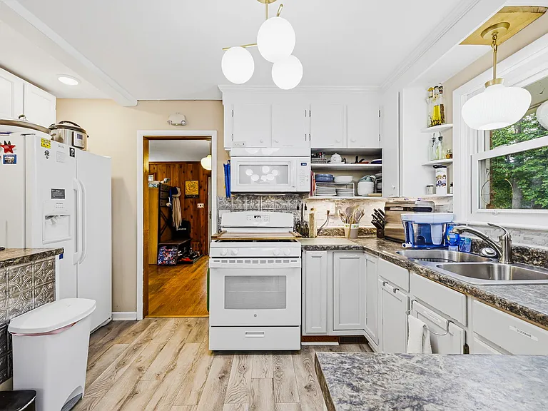 MAIN LEVEL: Kitchen with Refrigerator, Stove, and Sink (Dining Room with Double-opening French Doors leading to Back Porch behind camera) (UNSHOWN: LAUNDRY AREA, 1/2 BATH, AND GREAT ROOM AHEAD