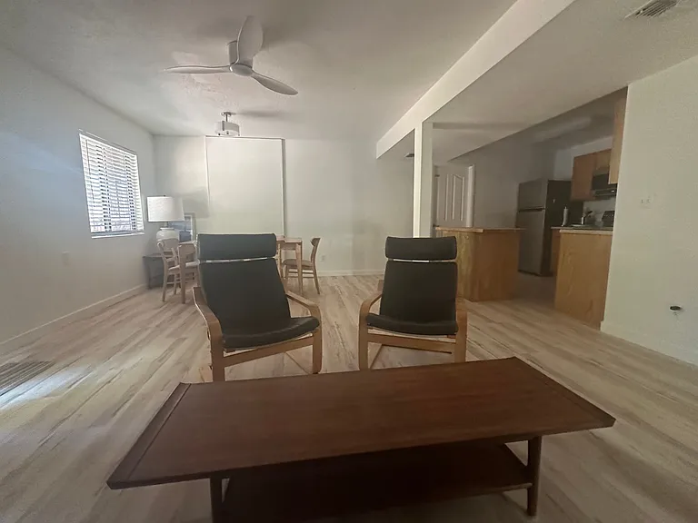 Living room with table and 6 chairs, coffee table, 2 ikea poang chairs and leather coach. Kitchen island.
