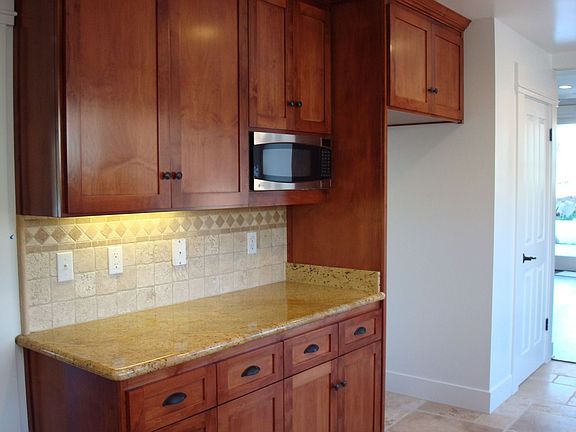 Another view of kitchen with sealed limestone flooring, large pantry