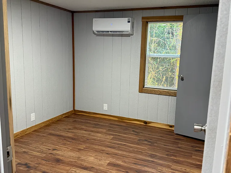 Bedroom 2 with 1 window, closet with hanging rack and its own mini split HVAC.