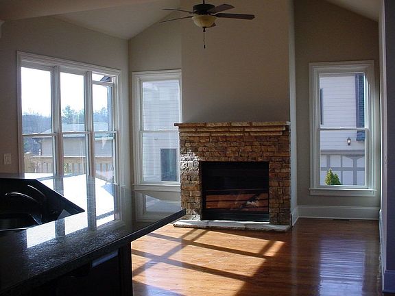 Keeping room with vaulted ceiling and stacked stone fireplace.