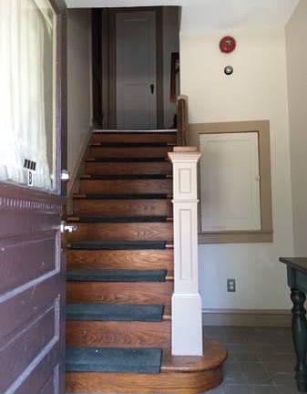 Private entrance. At top of stairs: bedroom/office space (left), half bathroom (center), and main apartment (right).