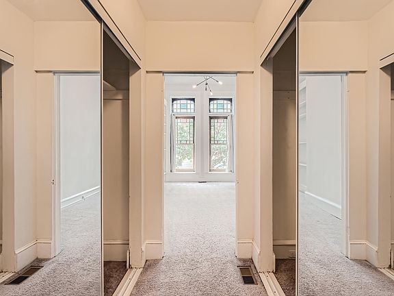 Hallway to bedroom with two large mirrored closets