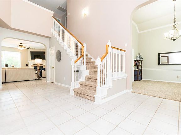 Dramatic two story foyer with staircase.