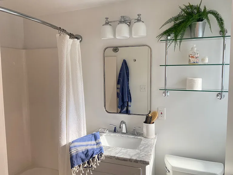 Updated bathroom with new vanity, mirror and lighting. Window on right!