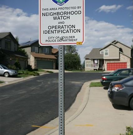 Neighborhood Watch warning sign near house (in back left of pic)