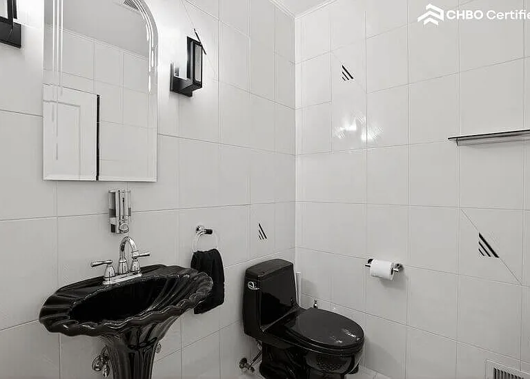 The main level hall bath has a stunning black and white look
