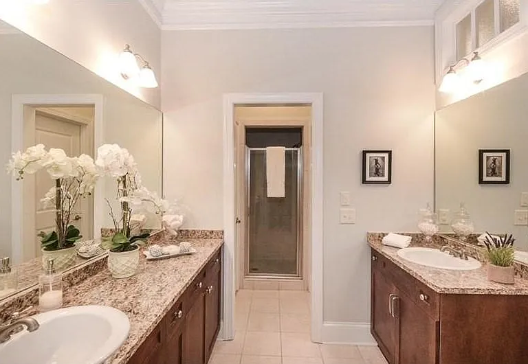 Dual vanity setup with wood-finish cabinetry and light-toned countertops