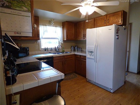 Kitchen has tile counter top, laminate hardwoods and dining area
