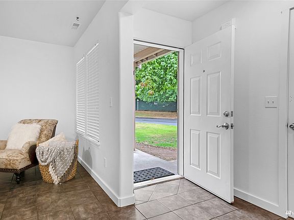 The tiled entrance provides a terrific space to remove shoes to keep the space pristine! The door to the left is the entrance to the spacious, 1-car garage!>
