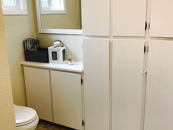 Bathroom has plenty of cupboards and a shower.
