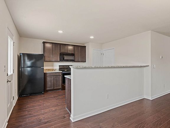The kitchen features granite countertops, recessed lighting, stunning wood cabinets, and more