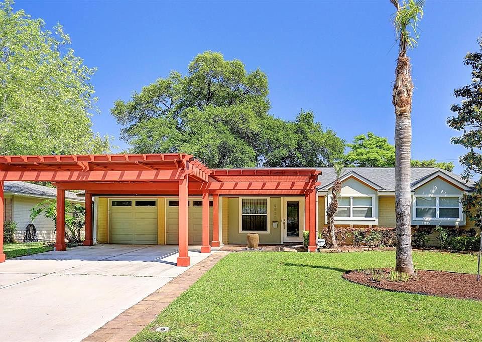 Front elevation with wonderful cedar carport, water feature and two car garage.