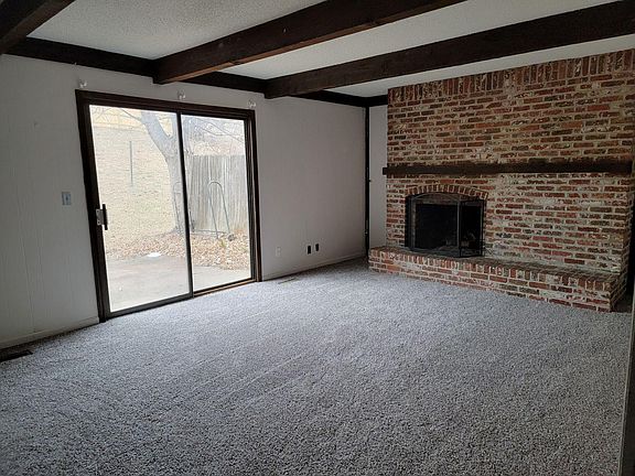 Large family room with wood burning fireplace and sliding doors to patio/backyard
