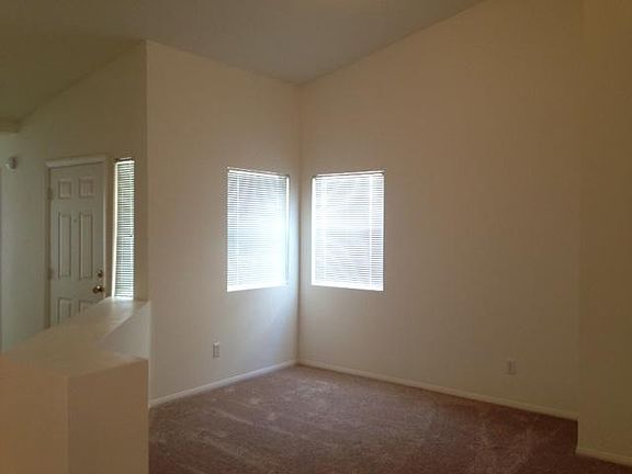 Den/office with cathedral ceiling, fresh paint, and new carpet.