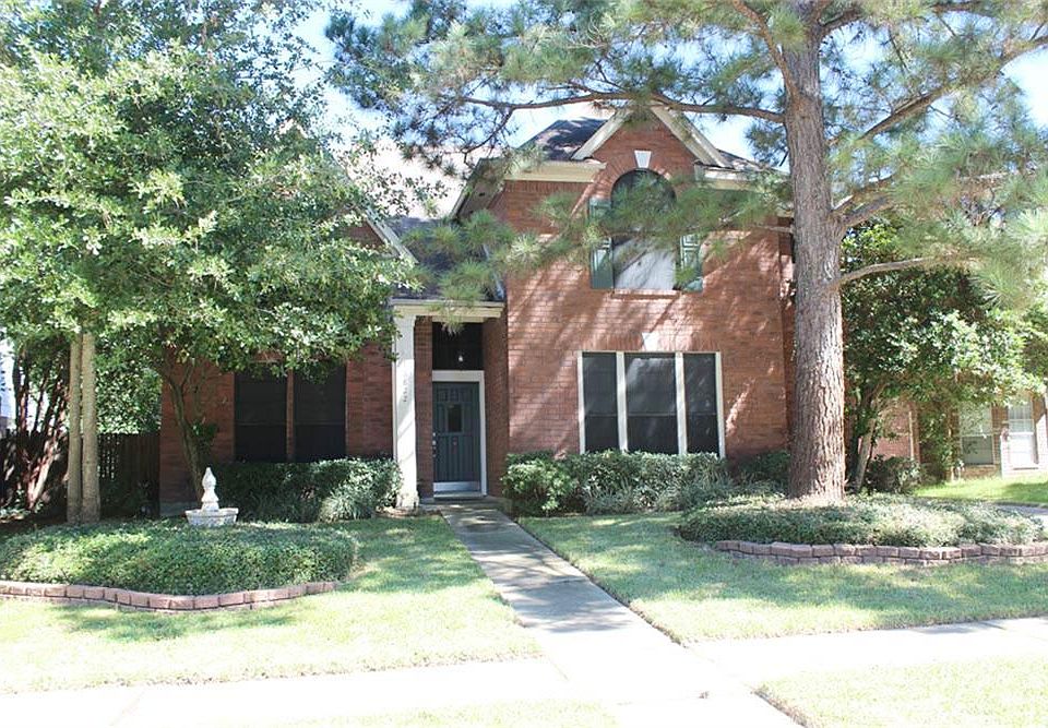 Front elevation of home with mature trees and landscaping.