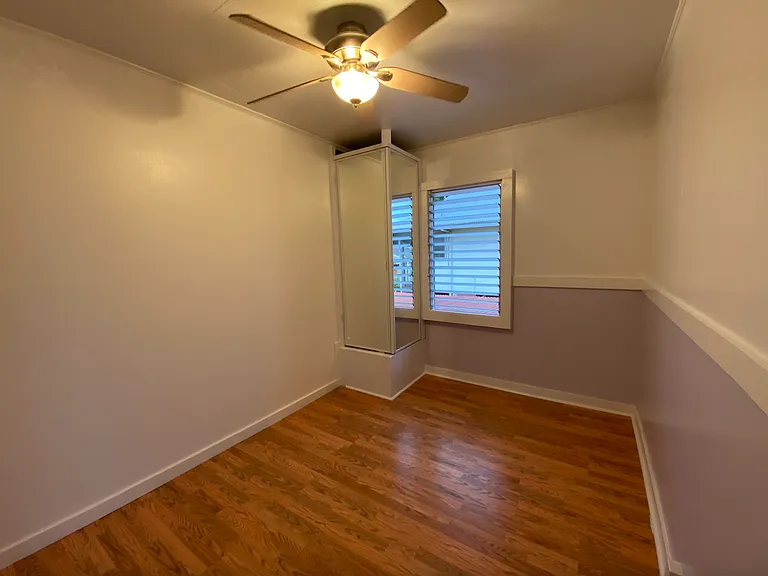 Middle purple bedroom with custom corner mirror closet doors