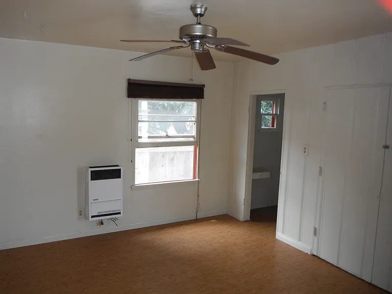 Living room showing ceiling fan and door to bath & closet