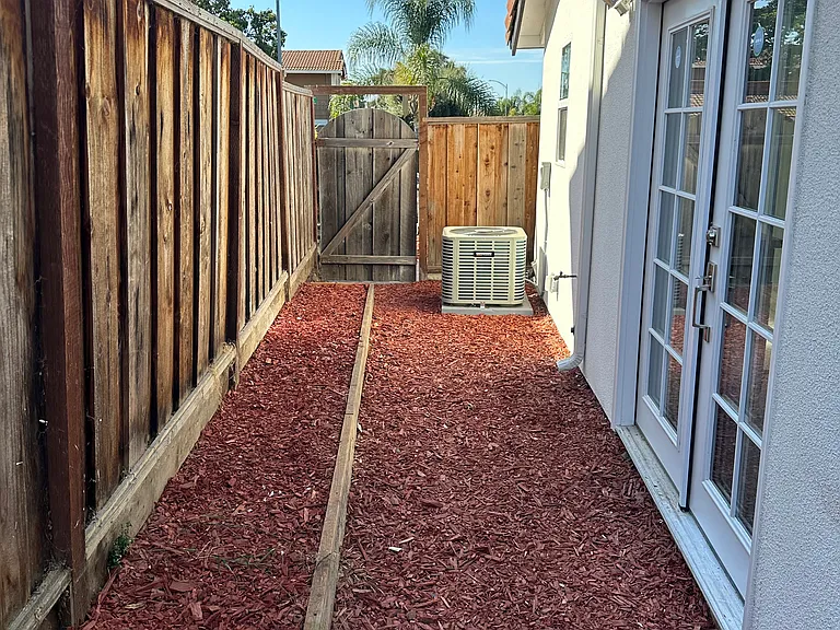 Private walkway to the side of the house where the unit is located.