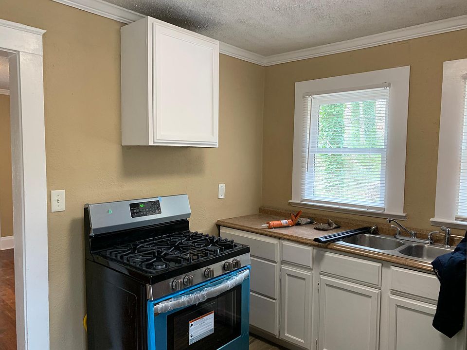 Renovated kitchen with new stainless steel appliances and tile flooring