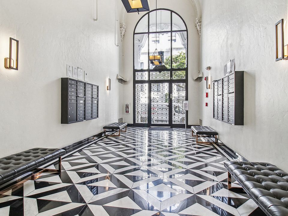 Lobby with a high, arched doorway and large glass panels allow natural light to brighten the space, wall-mounted mailboxes