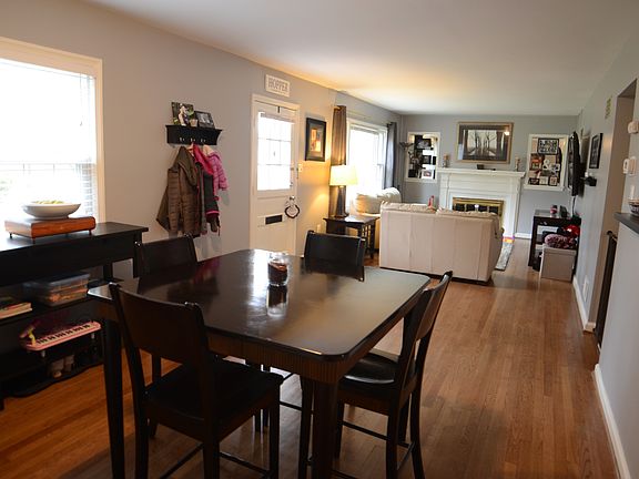 Open front living room and dining room with a fireplace and large windows.